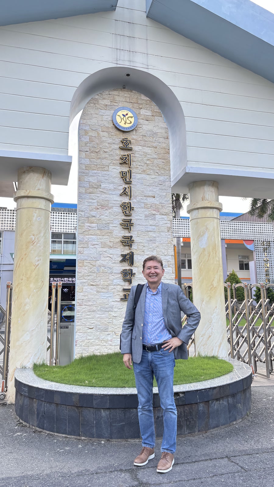 호치민시 한국국제학교 정문 표지 앞에 필자가 서 있는 모습